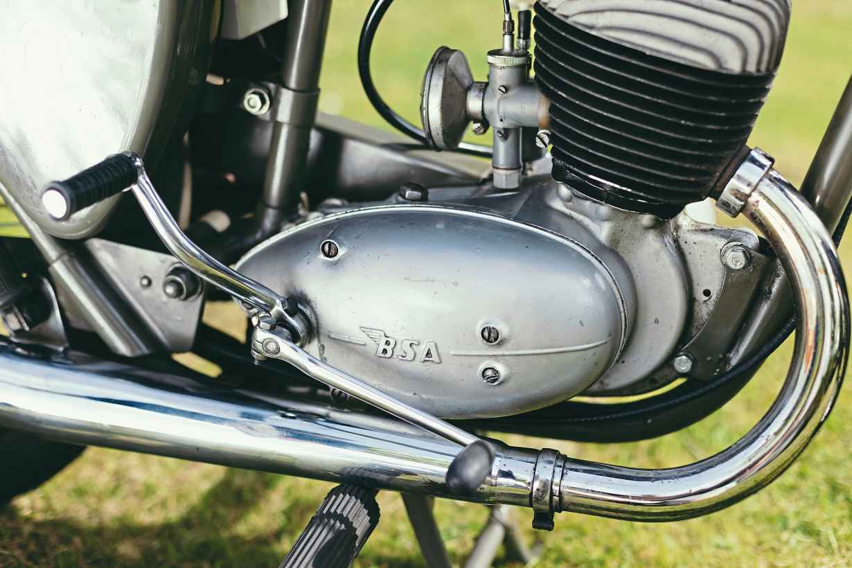 Amal carb with ‘strangler’ choke/air filter, new tool and battery boxes for new frame, and 1956’s longer, less restrictive silencer.